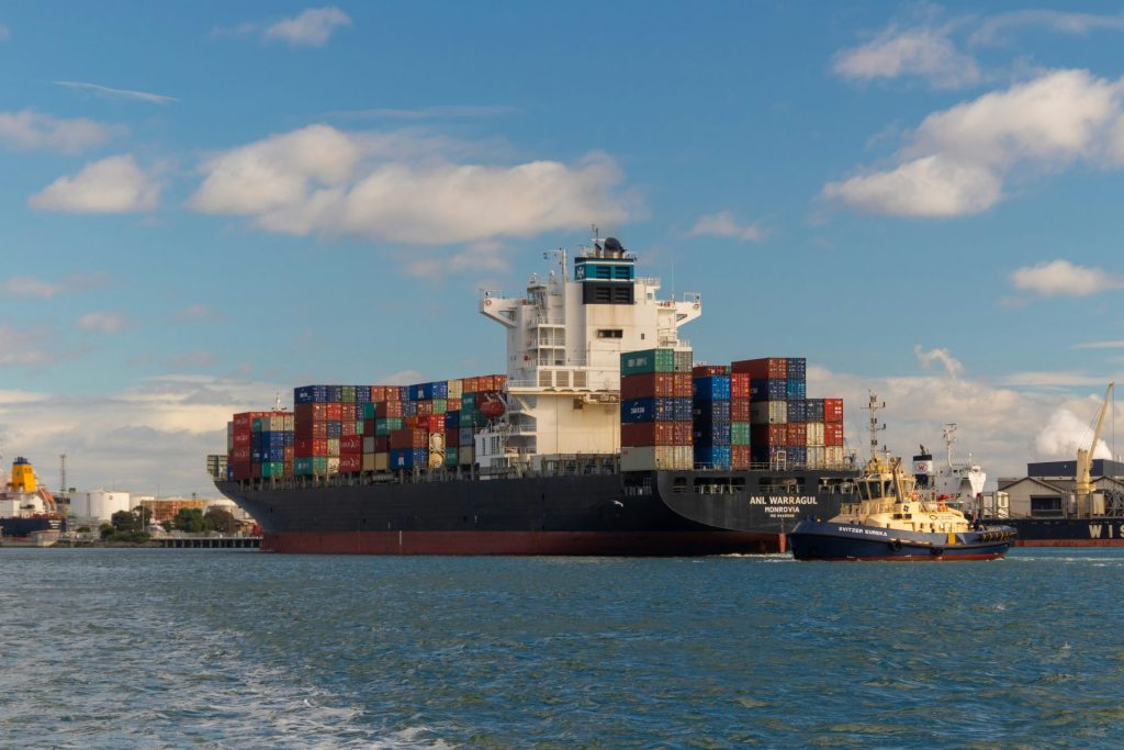 Container ship being escorted by a tugboat.